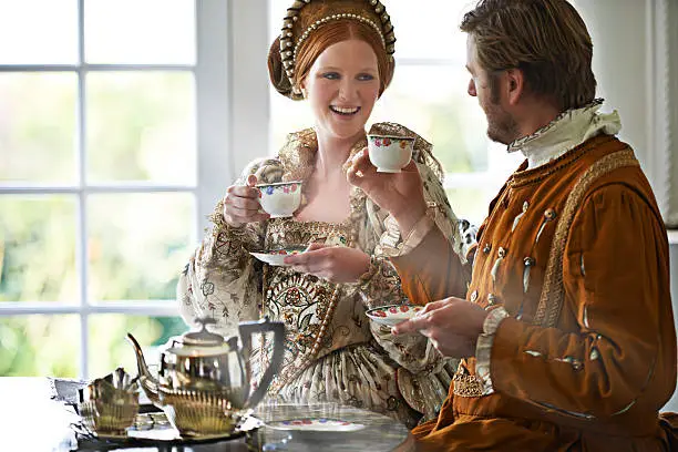 A king and queen taking tea together at home