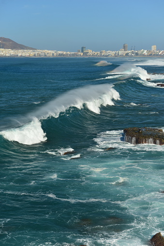 Winter surfing waves approaching the city of Las Palmas and Playa De Las Canteras from the Atlantic Ocean.