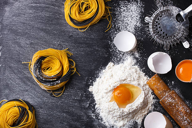 istock Raw homemade pasta and ingredients on a black background 514056608