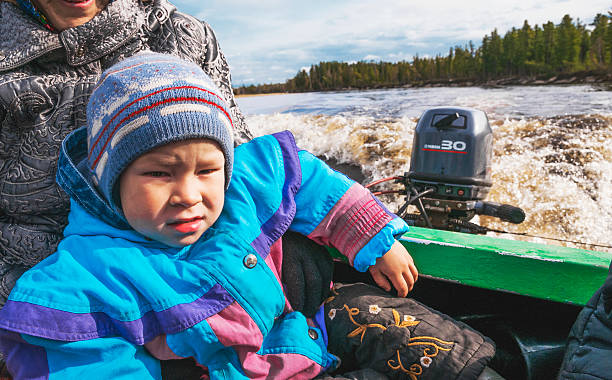 chico en un pequeño barco en el río en siberia occidental - pokachi fotografías e imágenes de stock