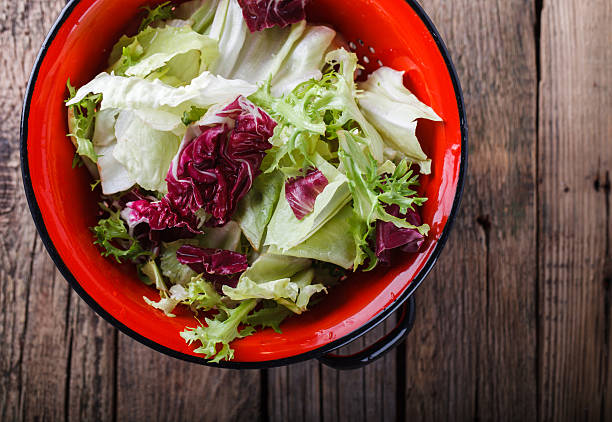 salada verde em um escorredor vermelho - distress rocket - fotografias e filmes do acervo