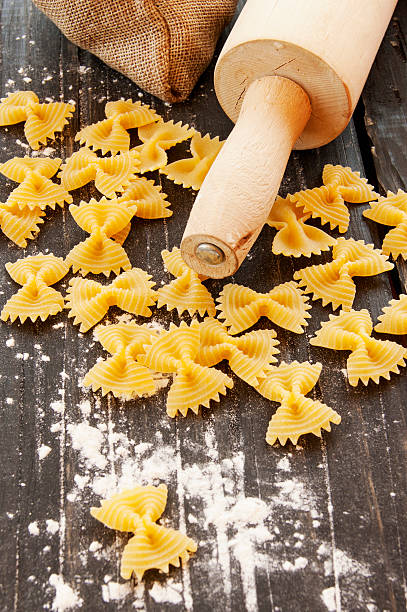 istock Uncooked pasta with flour on the table, selective focus 514064460