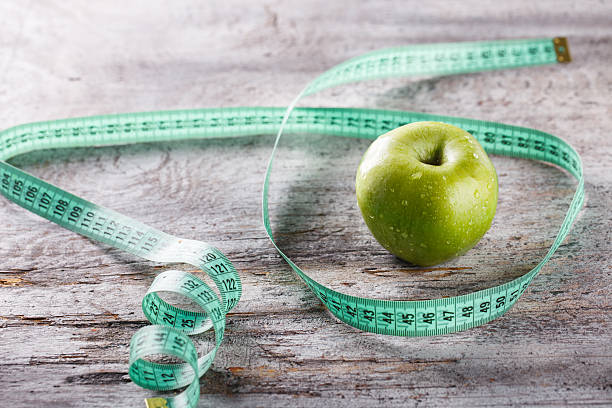 Green Apple and centimetre Green Apple and centimetre.Food or Healthy diet concept.selective focus. centimetre stock pictures, royalty-free photos & images