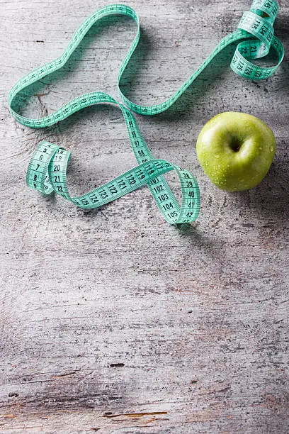 Green Apple and centimetre.Food or Healthy diet concept.Copy space.selective focus.