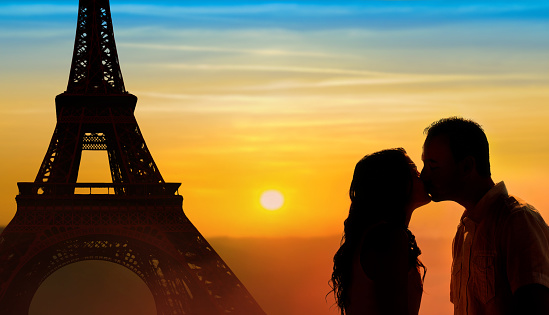 Backlit loving couple honeymoon in Paris with Eiffel tower and sunset background