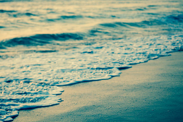 Abstract cross process toned horizontal photo of ocean, beach and slight waves. Actual tilt/shift lens used to exaggerate blur.