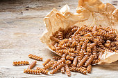wholemeal pasta fusilli from organic whole grain spelt on paper