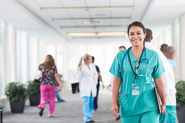 istock Confident young nurse walking through busy hospital 514076909