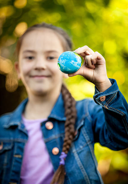 istock smiling girl holding little Earth at hand 514077843