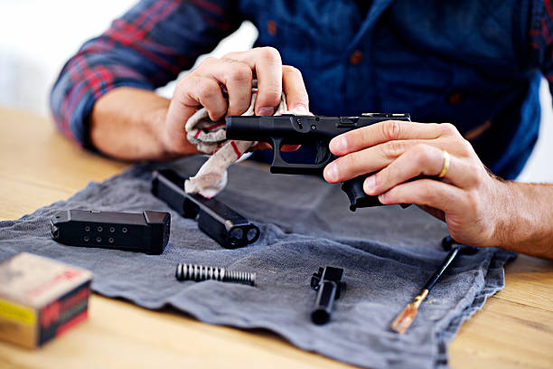 Regular maintenance is essential for every gun owner Cropped view of a man cleaning his gun gun cleaning stock pictures, royalty-free photos & images