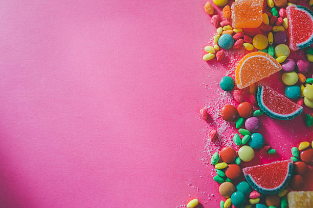 zucchero caramella in diverse forme e rosa spazio copia sullo sfondo - gelatin dessert multi colored vibrant color celebration foto e immagini stock