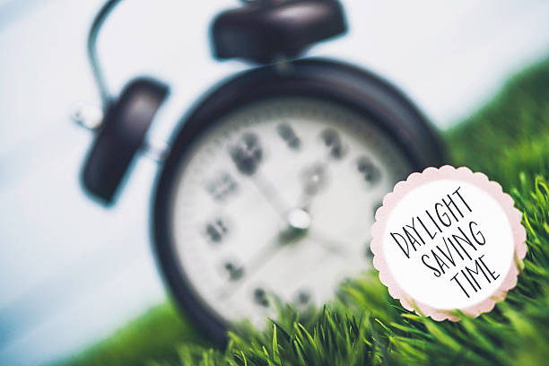 istock Clock in grass with reminder for Daylight Savings Time 514102406