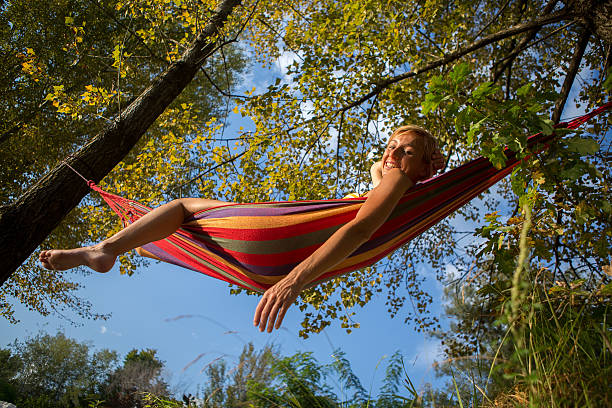 istock cheerful young woman relaxing on an hammock at sunset. 514102617