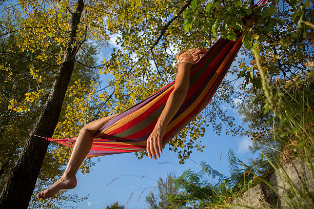 istock Young woman relaxing on an hammock at sunset. 514103475