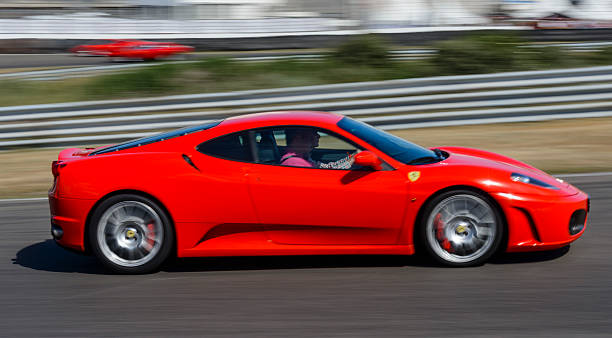 Ferrari F430 at high speed Zandvoort, The Netherlands - June 29, 2014: Red Ferrari F430 sports car driving on the Zandvoort race track during the 2014 Italia a Zandvoort day. ferrari ferrari f430 italian culture action stock pictures, royalty-free photos & images