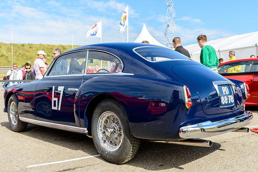 Zandvoort, The Netherlands - June 29, 2014: Blue Ferrari 212 Inter Ghia classic 1950s car in the paddock at the Zandvoort race track during the 2014 Italia a Zandvoort day. People in the background are looking at the cars.