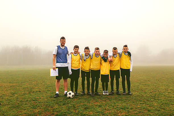 portrait de l'équipe des enfants avec entraîneur après jouant au football - championnat jeunes photos et images de collection