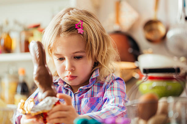 istock Cute Little Girl Opening Chocolate Easter Bunny 514108698