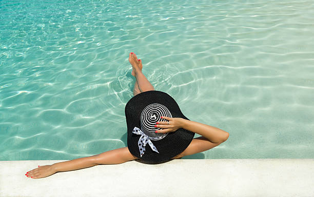 istock Woman in hat relaxing at the pool 514110509