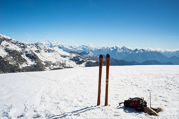 Ski tour equipment on the summit, majestic mountain range Ski tour equipment with climbing skin and backpack in scenic high mountain backgrounds in the Italian French Swiss Alps. Monte Rosa Massif at the horizon. switzerland european alps ski winter stock pictures, royalty-free photos & images