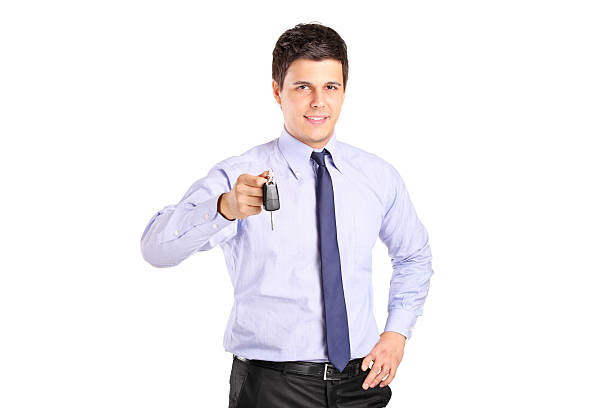 istock Young man holding a car key isolated on white background 514131829