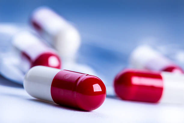 таблетки и tablets.blue фоне. - vitamin pill excess pill capsule стоковые фото и изображения