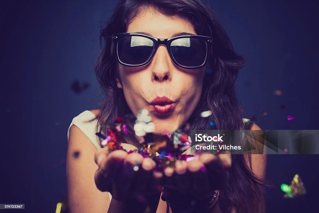 Party time Girl blwoing confetti Blowing Stock Photo