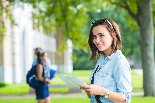 Young college student studying class schedule or campus map 