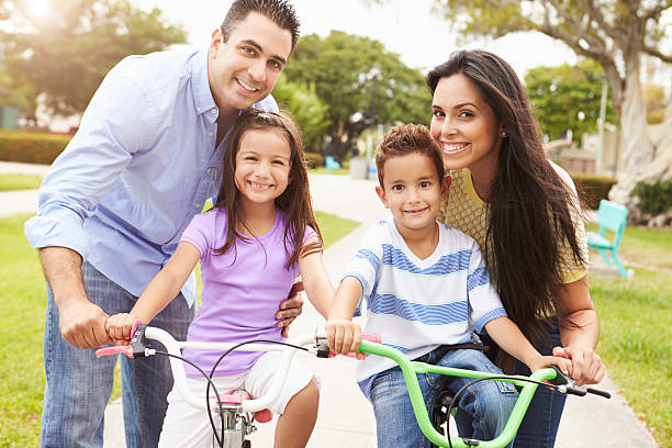 istock Parents Teaching Children To Ride Bikes In Park 514134649