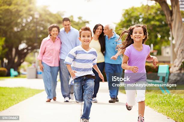 Multi Generation Family Walking In Park Together Stock Photo - Download Image Now - Family, Healthy Lifestyle, Latin American and Hispanic Ethnicity