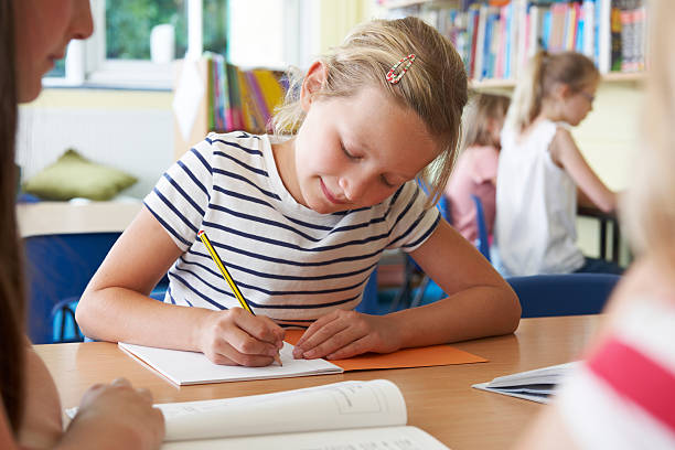 istock Elementary School Pupil Working At Desk In Classroom 514137595