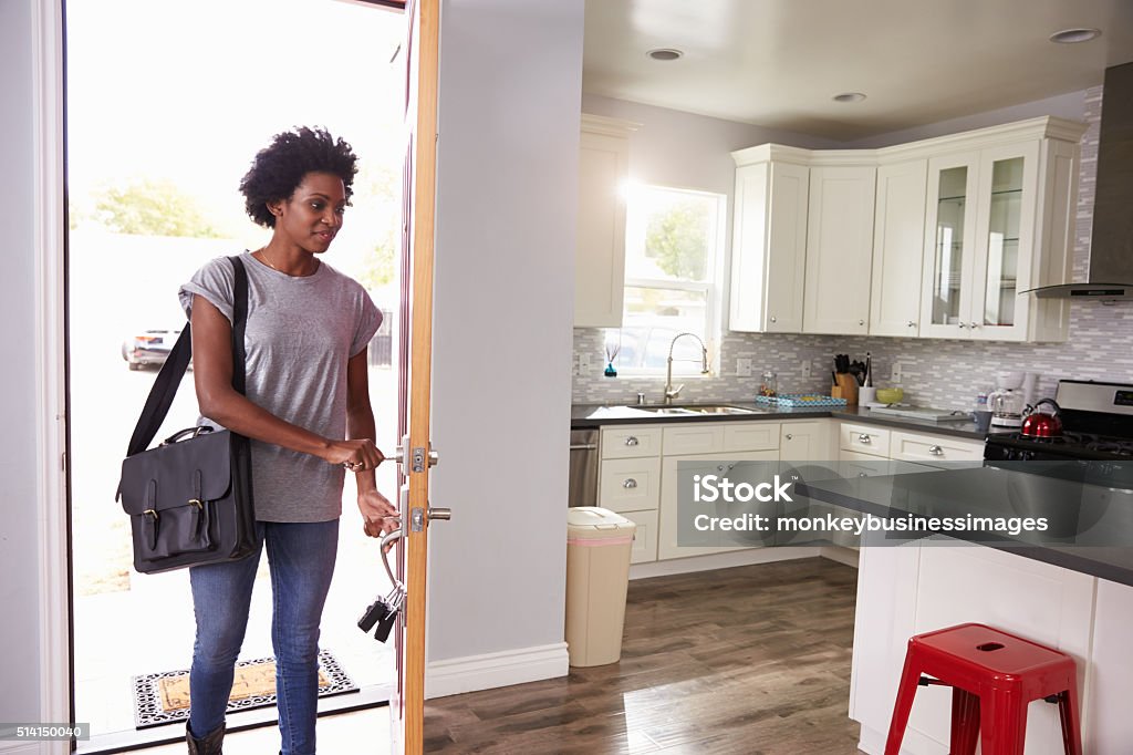 Frau, die zu Hause arbeiten und zu öffnende Tür des Apartments - Lizenzfrei Tür Stock-Foto