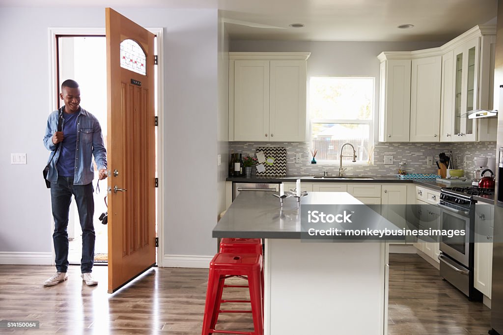 Man Coming Home From Work And Opening Door Of Apartment Door Stock Photo