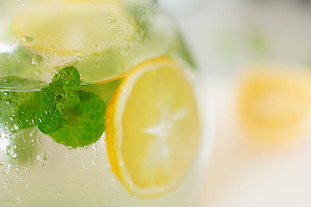 fresh lemonade with lemon and peppermint leaf in jug fresh lemonade with lemon and peppermint leaf in jug lemon soda photos stock pictures, royalty-free photos & images