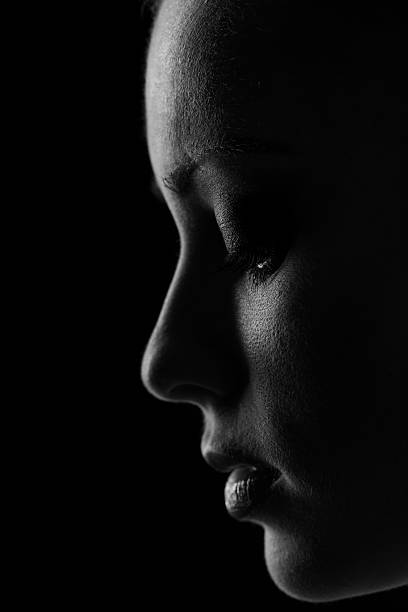 istock Woman portrait silhuette in darkness with soft light on face. 514152736