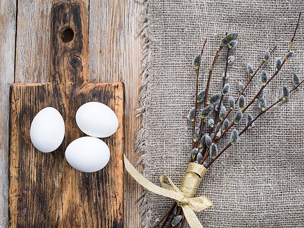 Eggs on a cutting board, rough napkin and willow twigs