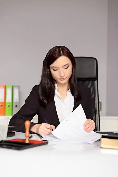 Photo of Brunette woman Notary Public reading testament.