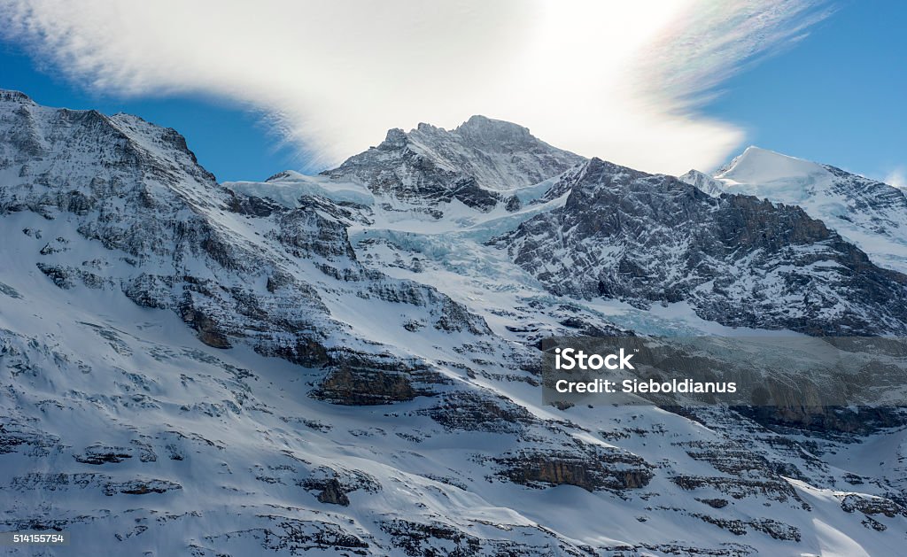 Alpine mountain peak (Jungfrau) with some Glacier relicts. Blue Stock Photo