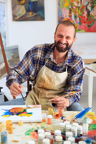 istock Cheerful artist in his workshop painting 514157476