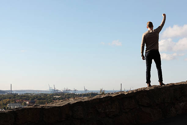 Man on top of mountain cityscape