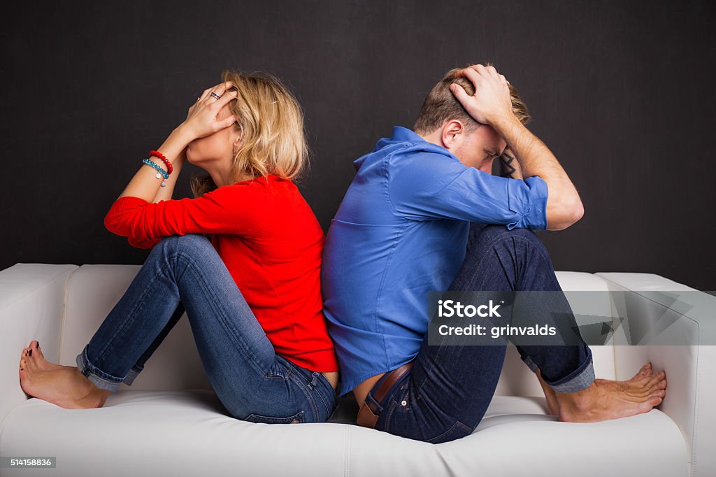 Couple with their backs turned to each other Couple with their backs turned to each other sitting on couch Couple - Relationship Stock Photo