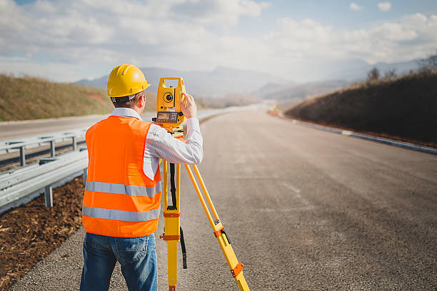 Land surveyor with total station Land surveyor with total station theodolite photos stock pictures, royalty-free photos & images