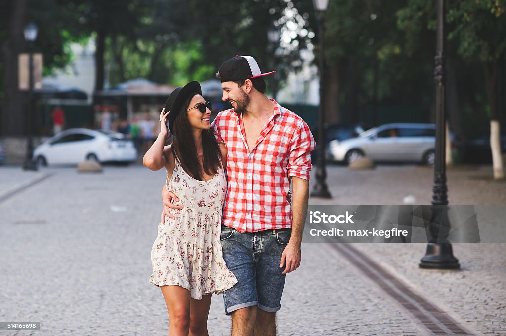 Hipsters walking on summer day Smiling couple of young people embracing and walking together on walking street. Hipsters wearing casual clothes walking on summer day 20-29 Years Stock Photo