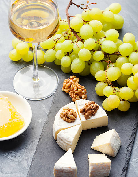 istock Glass of white wine and assorted cheese with grape 514168966