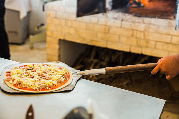 istock Close up adult men holding pizza peel 514169152