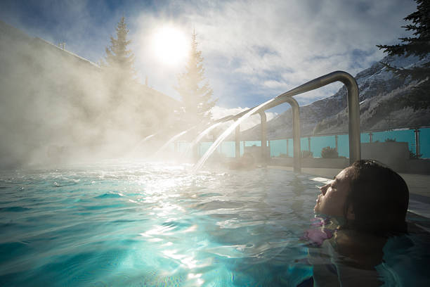 Young Asia woman enjoy hot spring under sunshine Hot spring in Switzerland hot spring stock pictures, royalty-free photos & images