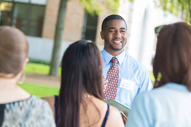 Potential students listening to guide during college campus tour