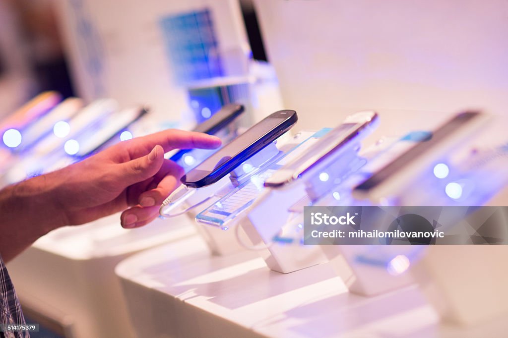 Buying Smartphone Unrecognizable people choosing smartphone in electronics store Store Stock Photo