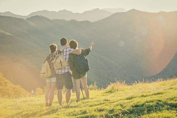 istock Three friends hug themselves looking panorama on mountain at sunset 514177293