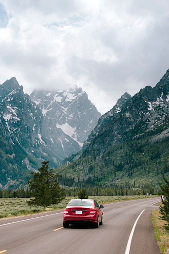 A car travels through the Teton Mountain Range.